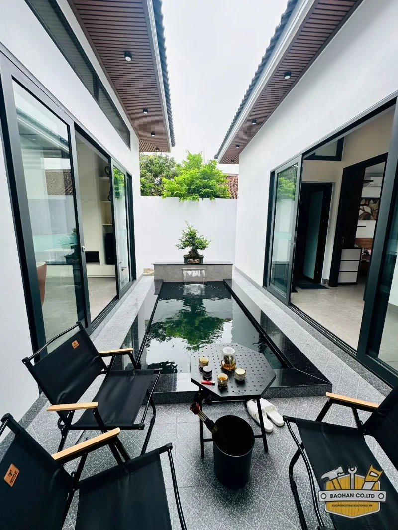 Khu vực trời với hồ nhân tạo và bộ bàn ghế gấp thư giãn