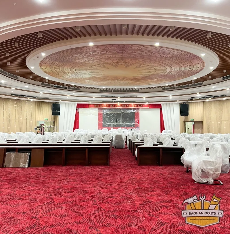 Phòng hội nghị được trải thảm đỏ với bàn gỗ và ghế văn phòng